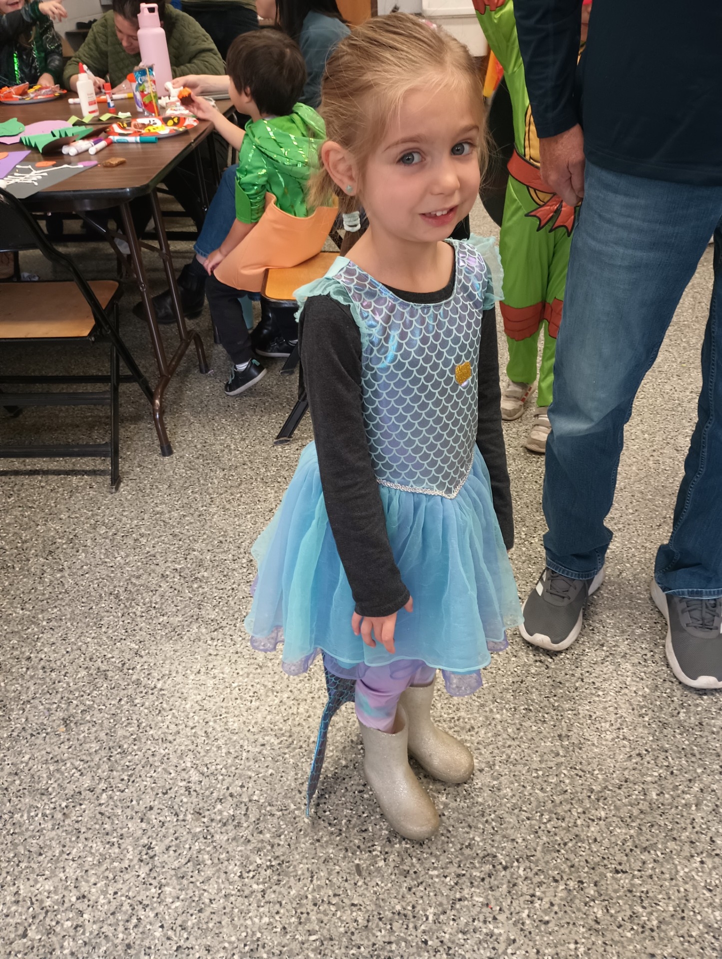 A young girl in a blue dress and glittery boots.
